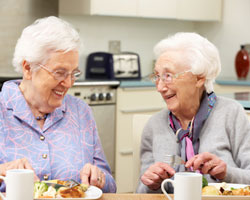 Einkommensteuer Rentensteuer - Zwei Heimbewohnerinnen beim Mittagessen