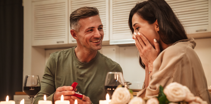  Ein Mannes, der seiner Freundin bei einem romantischen Abendessen einen Heiratsantrag macht.