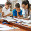 Lehrerin sitzt mit ein paar Schulkindern über Aufgaben.